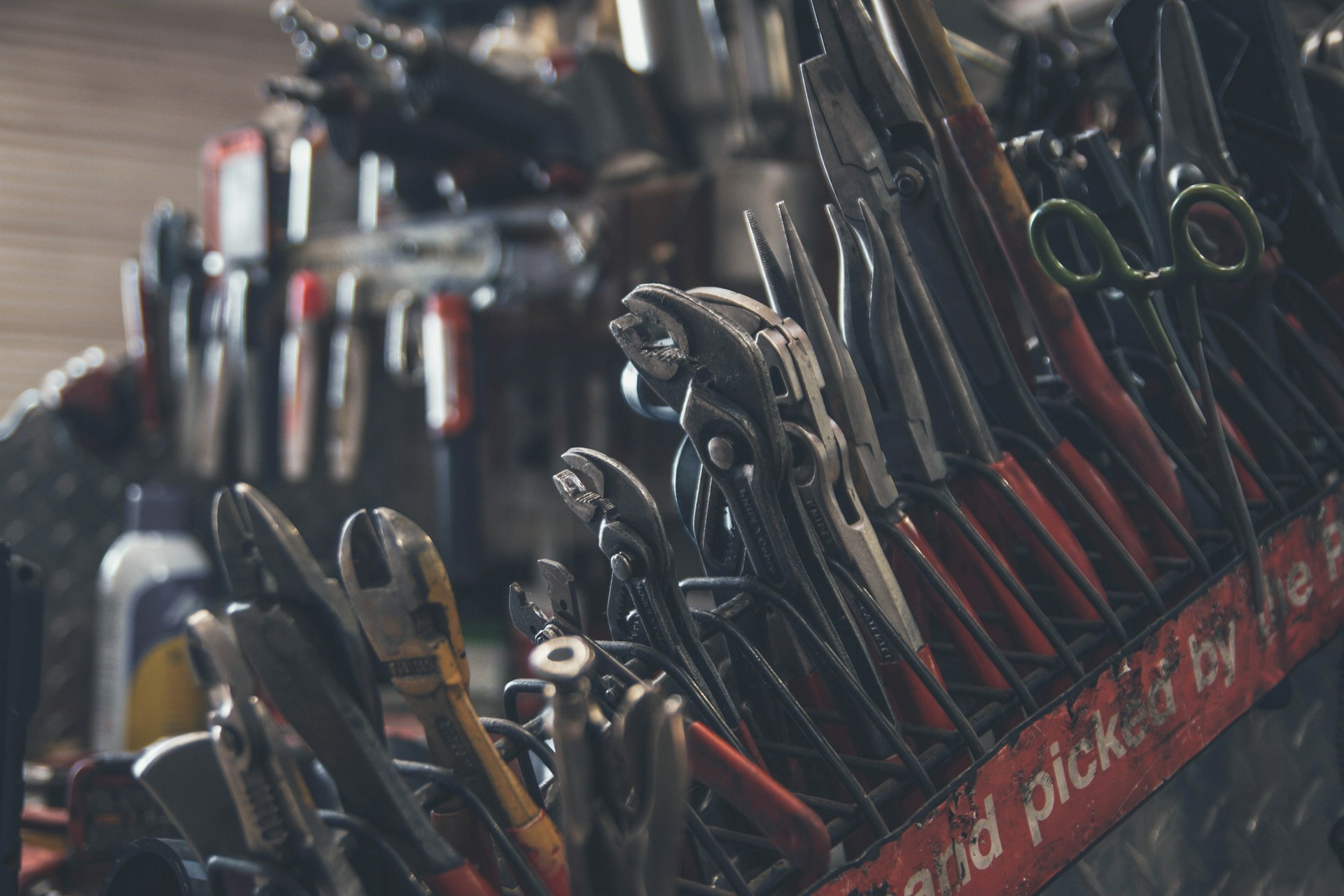 Wall of pliers, screwdrivers, and hand tools organized on a tool rack
